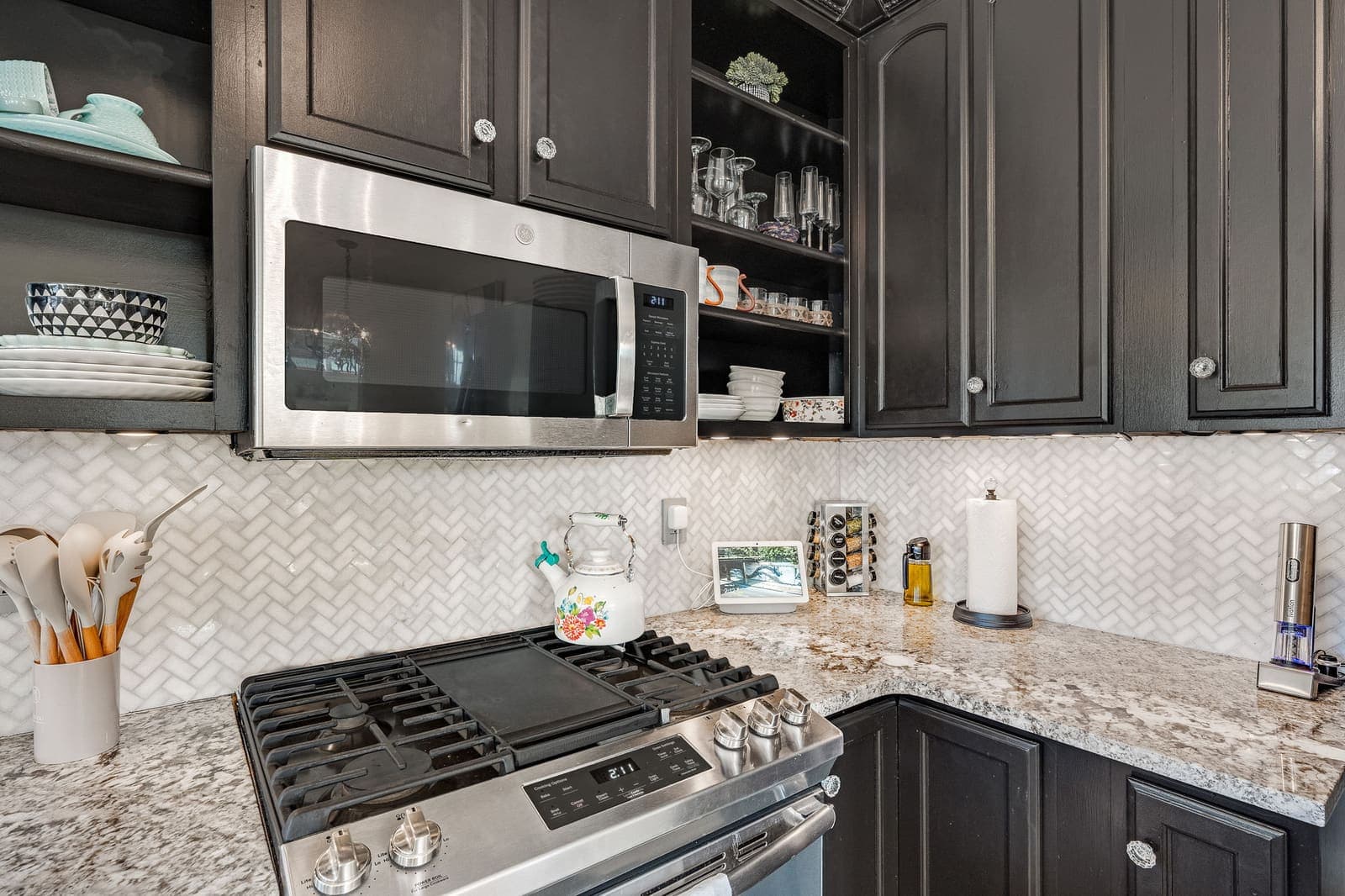 Gas range and herringbone tile backsplash